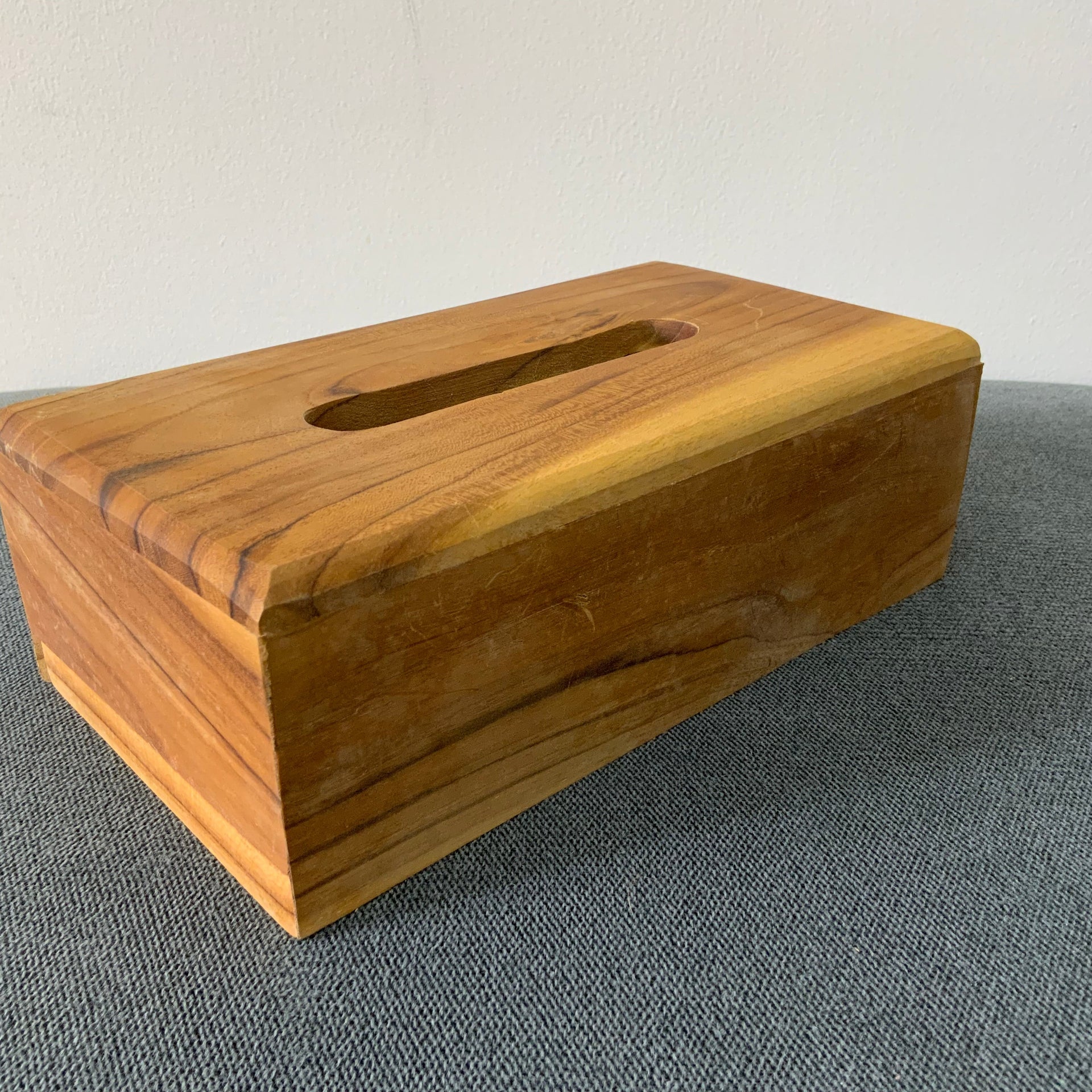 Natural wood rectangular tissue box cover with a smooth finish."Natural wood rectangular tissue box cover with a smooth finish.