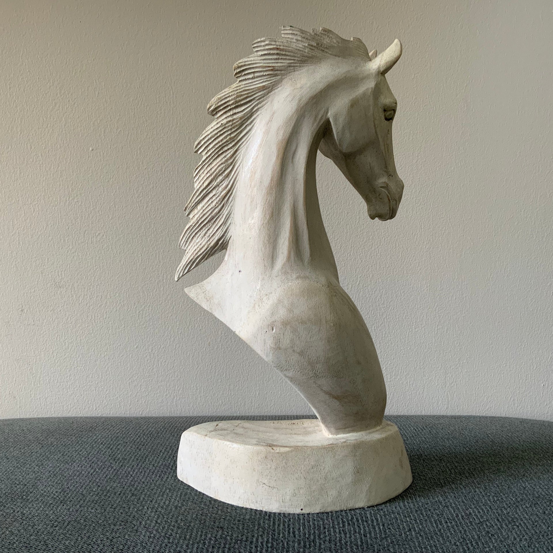 Whitewashed horse sculpture in a gray surface